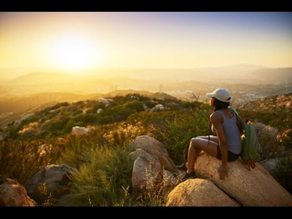 Woman hiker stopping to enjoy the sunrise view, Carlsbad, California. 